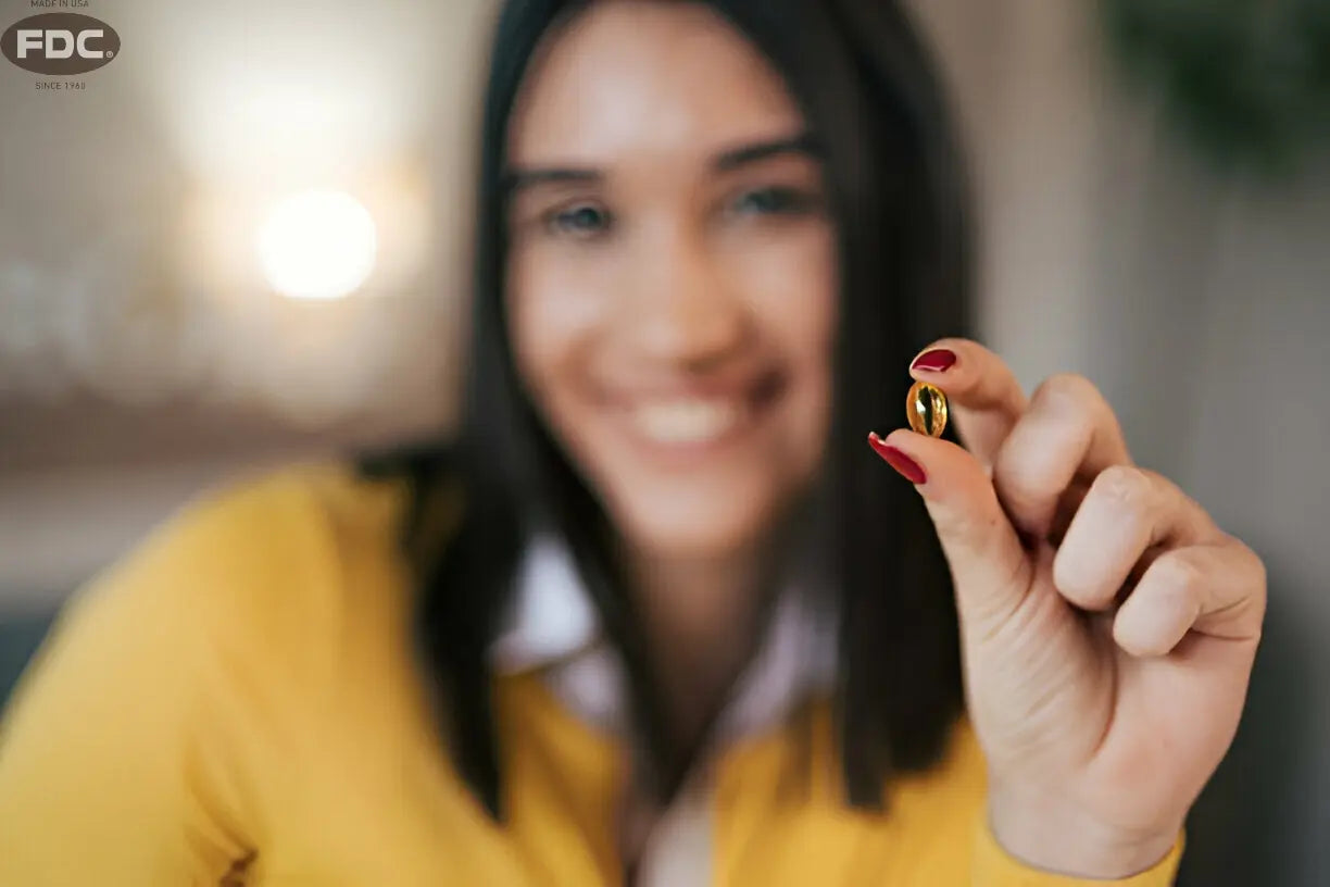 Mulher sorrindo segurando cápsula de ômega-3, destacando saúde e bem-estar.