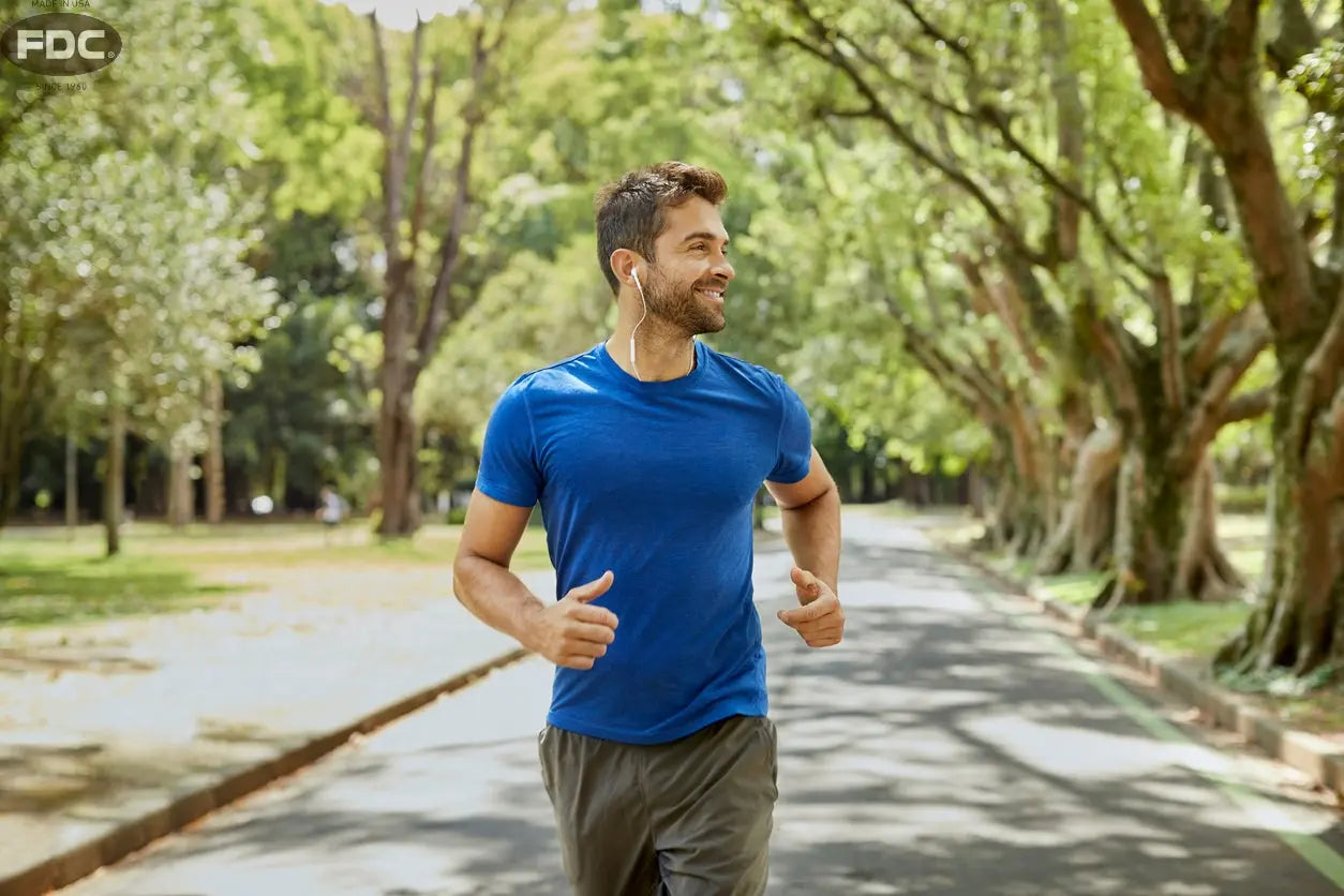 Homem correndo em parque arborizado, simbolizando saúde e bem-estar masculino.