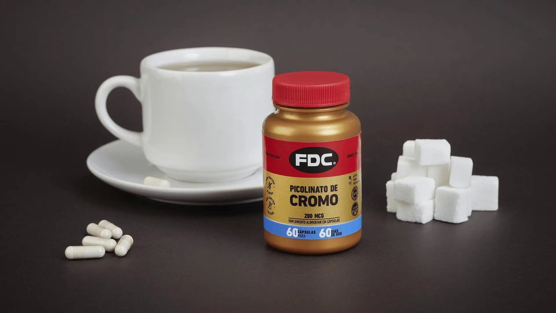 Picolinato de Cromo FDC ao lado de xícara de café e cubos de açúcar.