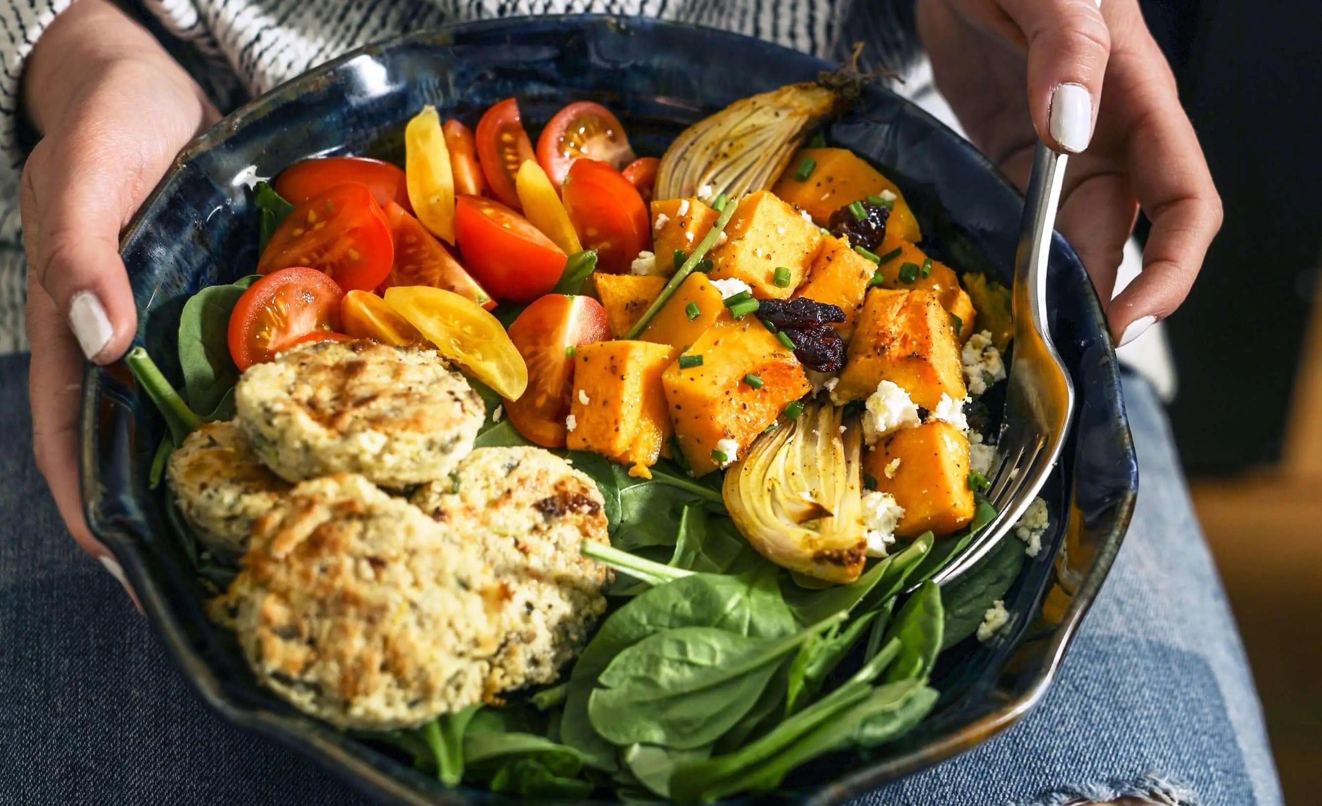 Texto alternativo:Prato vegetariano colorido com vegetais frescos e hambúrgueres vegetais.