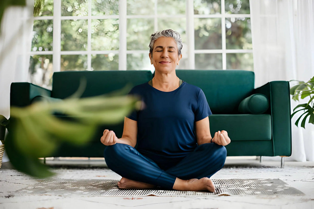 Texto alternativo:Mulher meditando em casa, promovendo saúde mental no Janeiro Branco.
