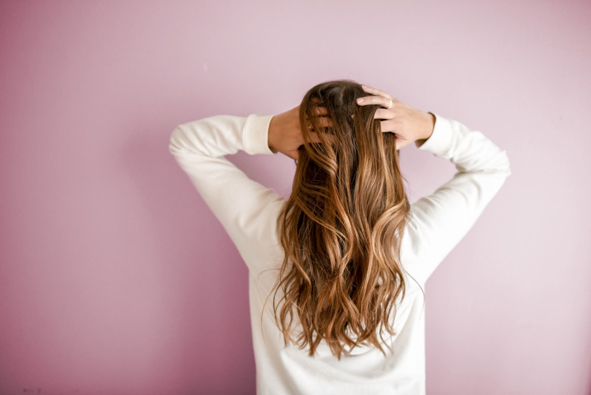 Mulher com cabelo saudável e pele luminosa — suplemento Hair Skin Nails e nutrição